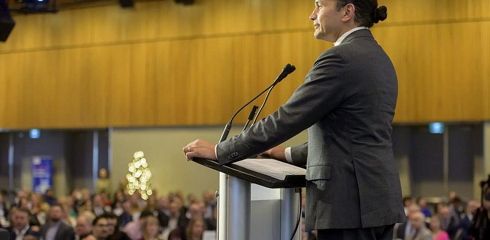 Premier Wab Kinew on stage speaking to Winnipeg Chamber of Commerce members at State of The Province 2024