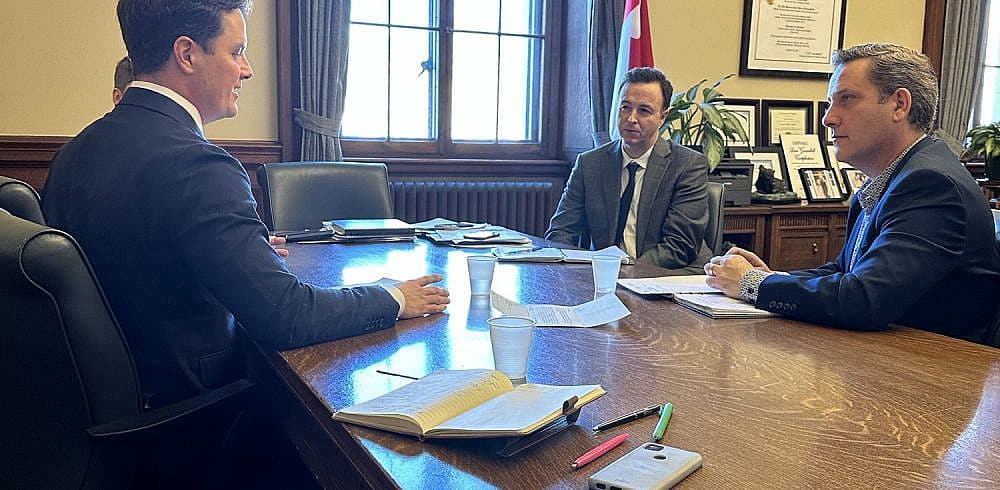 Three men sitting at a table.